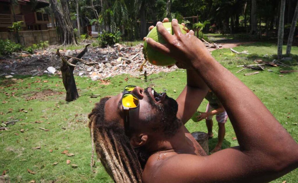 Descubre la Vida Bomber 22 Bomber equipo surfista bebiendo coco agua con Bomber gafas de sol