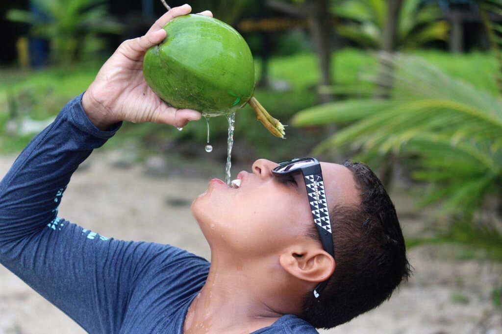 ¡Nuevo contenido del equipo próximamente! 18 Surfista con Bomber gafas de sol y bebiendo un coco