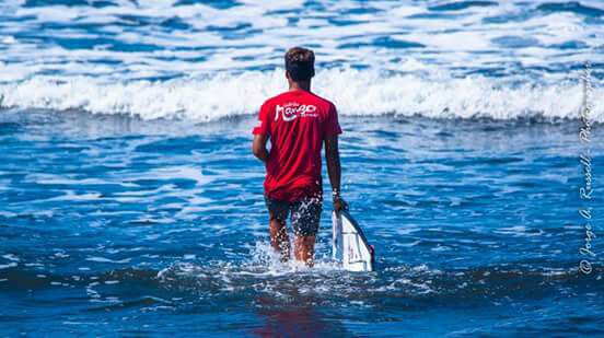 ¡Nuevo contenido del equipo próximamente! 14 Bomber Floating Eyewear Latin America surfista caminando hacia las olas en Jacó
