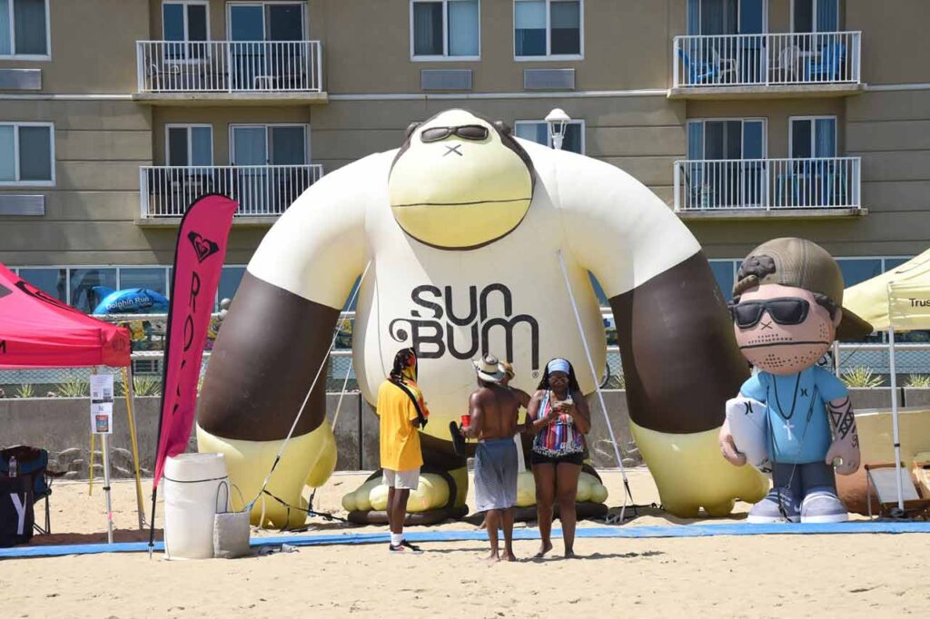 Descubre la Vida Bomber 17 Mono gigante SUNBUM en la arena del Concurso de Surf de la Costa Este de Virginia Beach, donde Bomber Floating Eyewear es un patrocinador